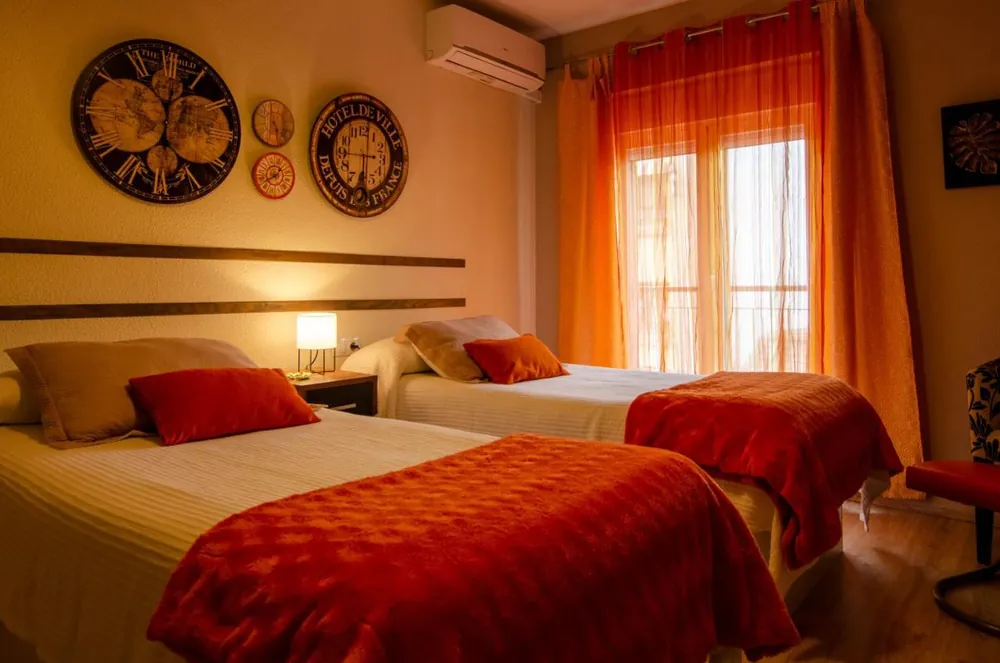 Dormitorio con dos camas y balcón